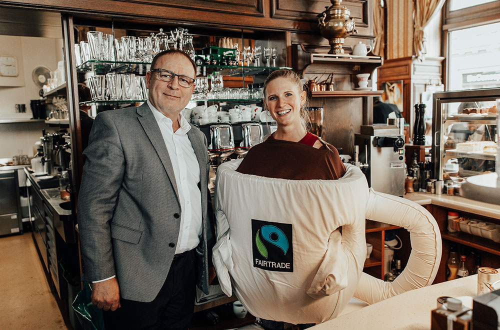 Franz Erhardt, Betriebsleiter des Café Schwarzenberg und Angelika als FAIRTRADE-Kaffeetasse.